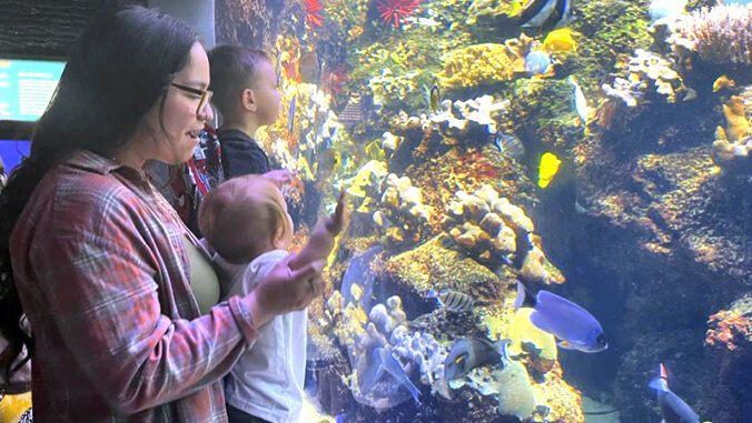 woman and child looking at large aquarium